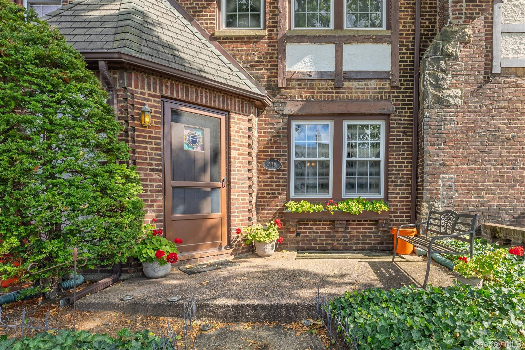 Beautifully maintained Tudor style home featuring classic brick and stone exterior.