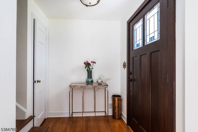 Classic Cape Cod with extensive custom updates, surrounded by manicured gardens and mature trees with deck, several patios and walkways.