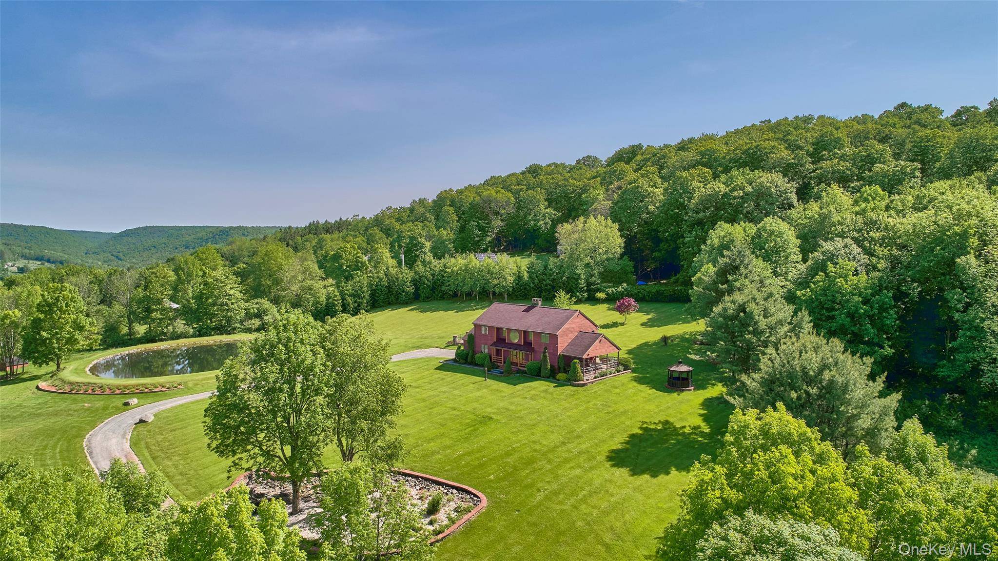 This mountaintop contemporary sits on 15 private acres with unparalleled views of the western Catskills, miles of hills and valleys, and an expansive, rolling lawn.