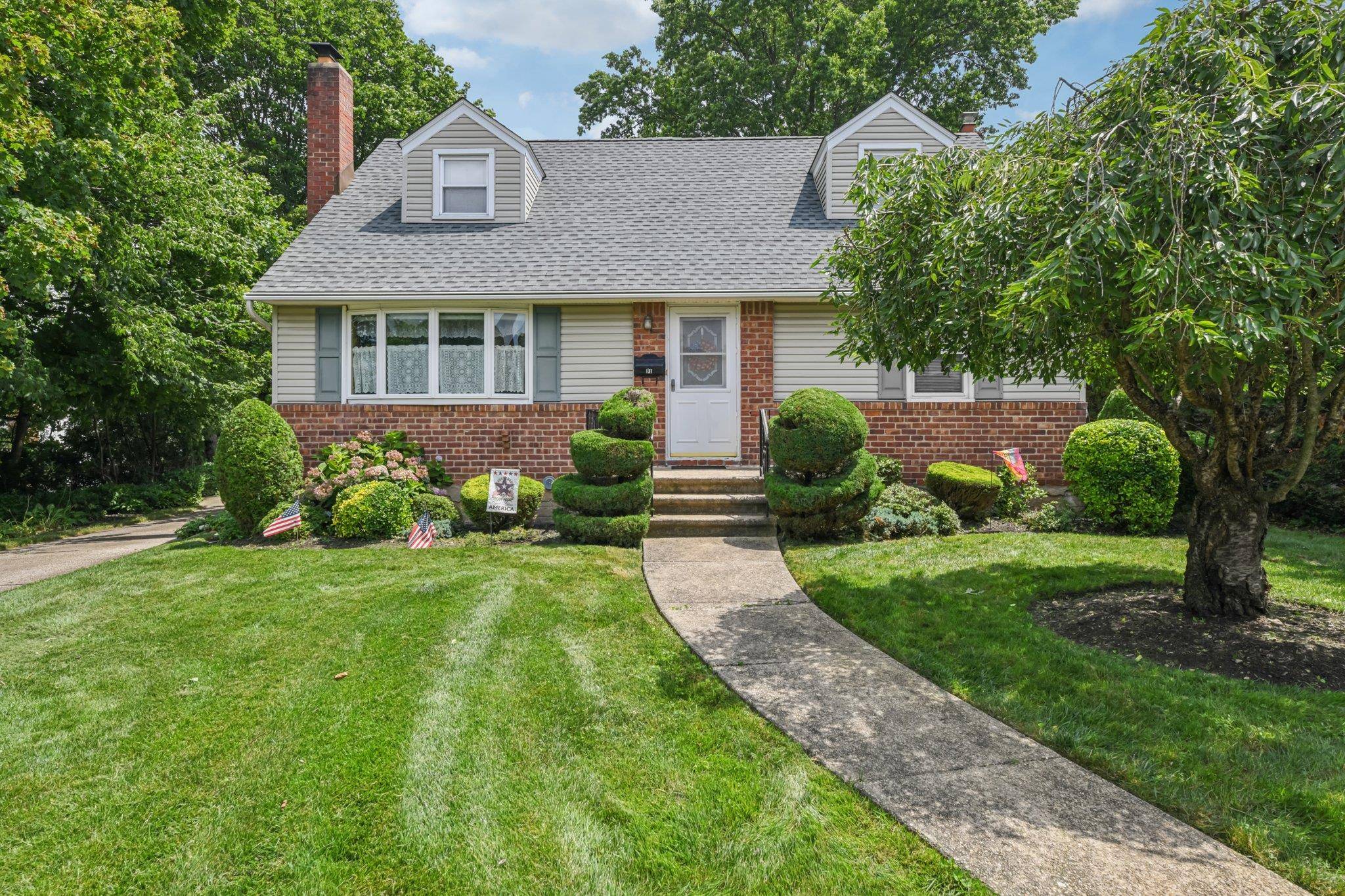 Presenting this Lovely Cape Cod House with brick and vinyl siding and detached garage with carport.