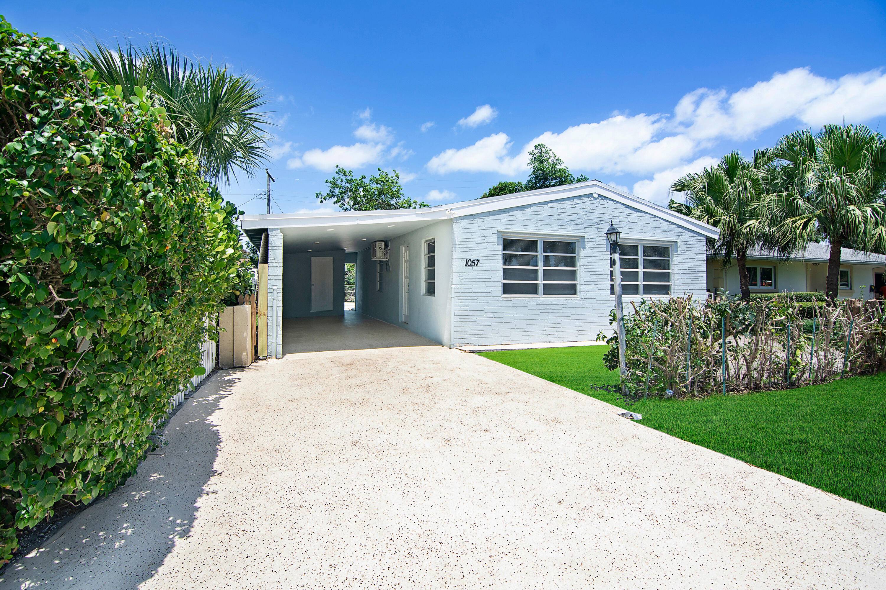Beautifully remodeled 3BR 1BA home in Lake Worth featuring quartz countertops, premium tile backsplash, and a stunning modern bathroom with a frameless glass shower and matte black finishes.