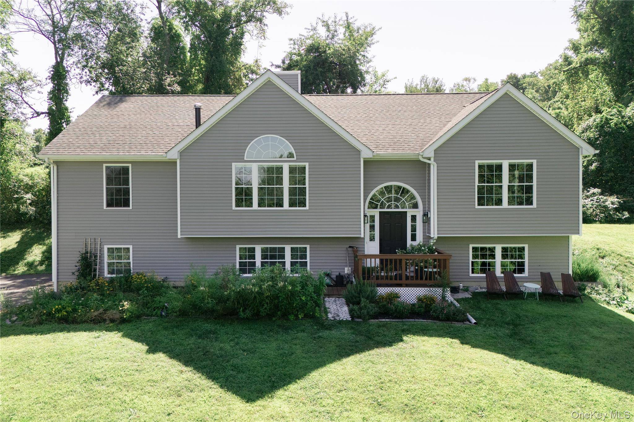 Nestled at the end of a long private drive, this 2017 built contemporary raised ranch sits on over 1.