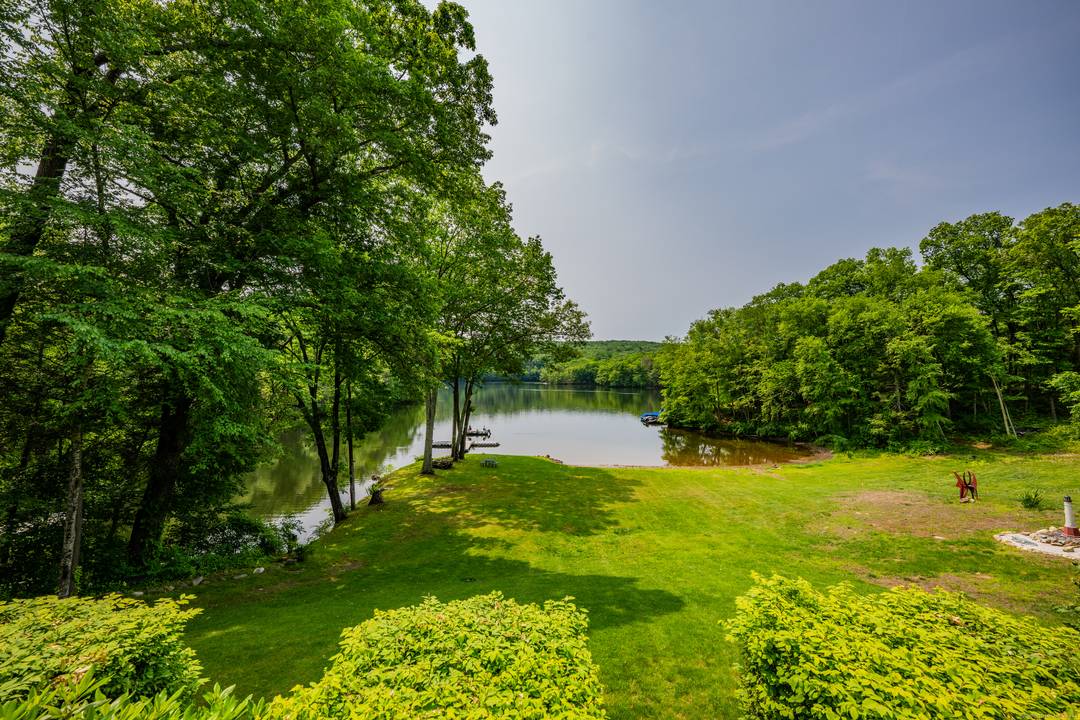 Grand post and beam home with level lake frontage and views, babbling brook, main level master suite, 9 car garage, finished walk out, and unfinished loft spaces for potential for ...