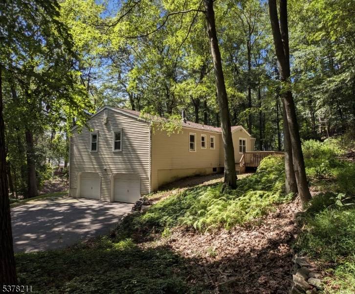 Nestled on a tranquil wooded lot bordering Parsippany Troy Hills in the coveted Puddingstone area, just steps from scenic Shongum Lake, this inviting 4 bedroom, 2.