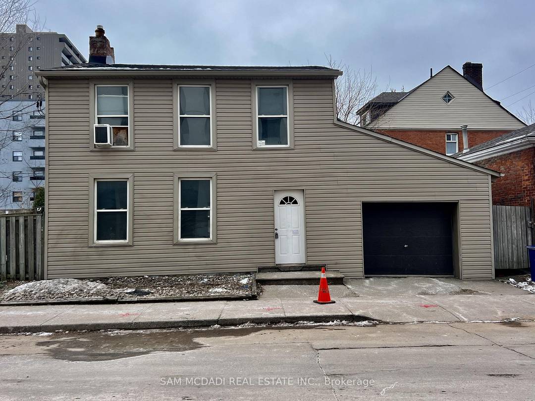Discover a rare investment opportunity in a prime downtown Hamilton location, set on a generously sized parcel with private driveway, laneway access, and detached garage.