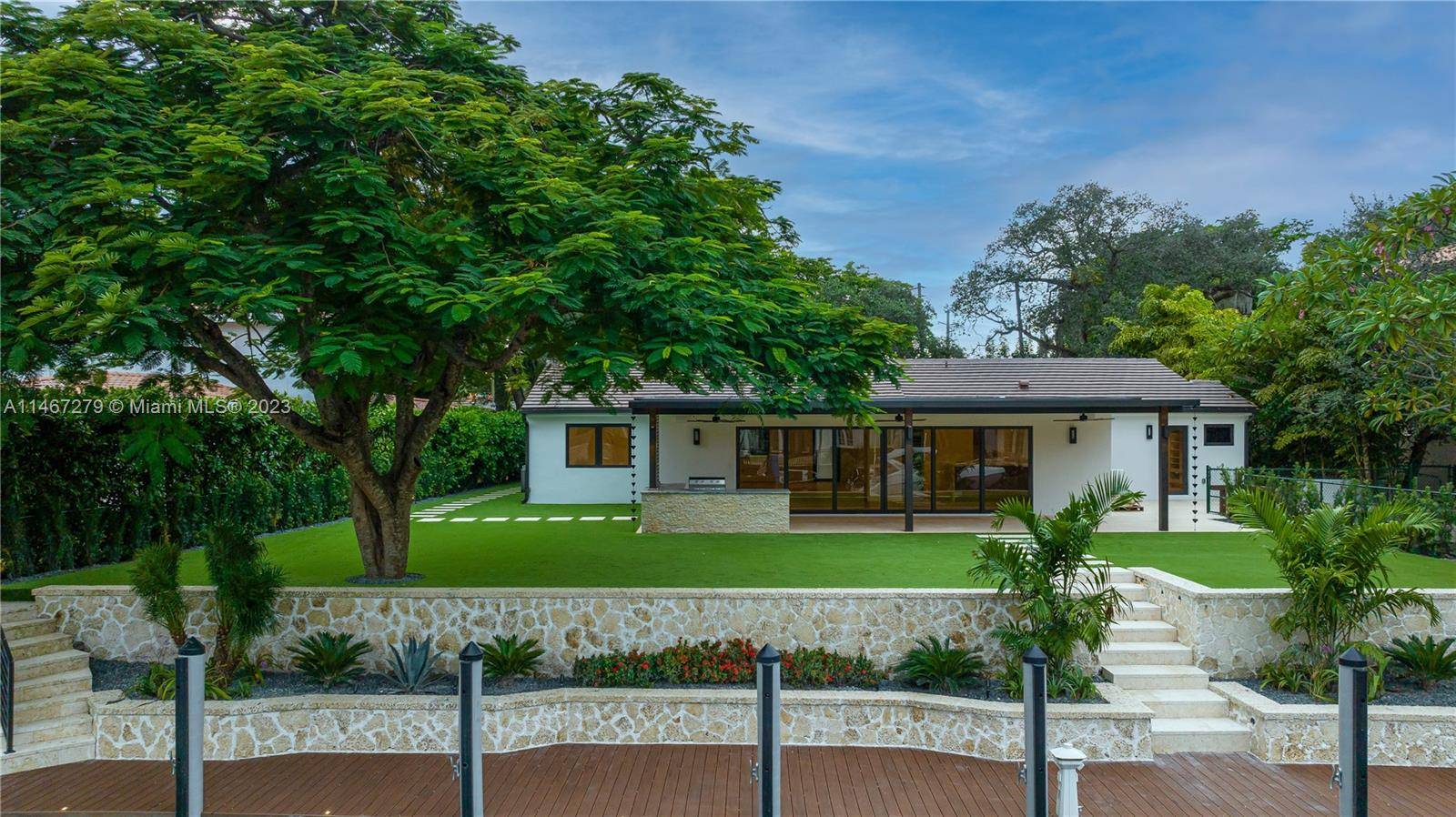 Located on quiet tree lined street at end of cul de sac, circular drive, impact glass doors windows 12 foot vaulted ceilings spacious living room with view of backyard waterway.