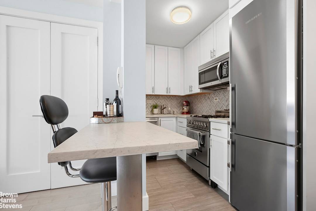 Near mint condition alcove studio with a wall of windows, and the feel of a one bedroom.