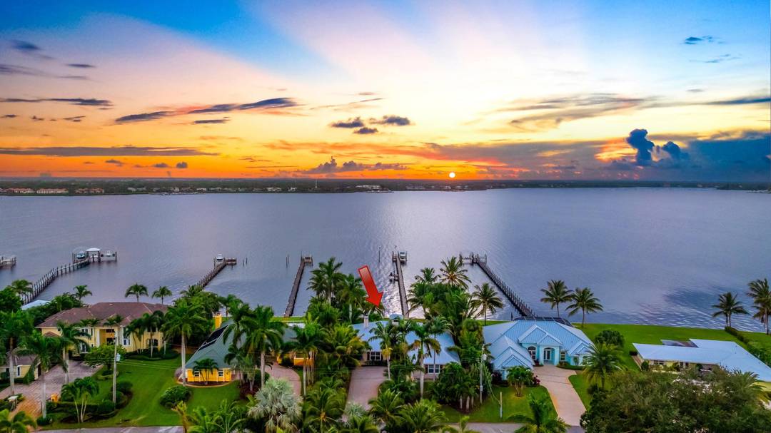 Stunning 4BR den 3BA Key West style waterfront estate in prestigious Beau Rivage, offering panoramic water views throughout and breathtaking sunsets over the St.