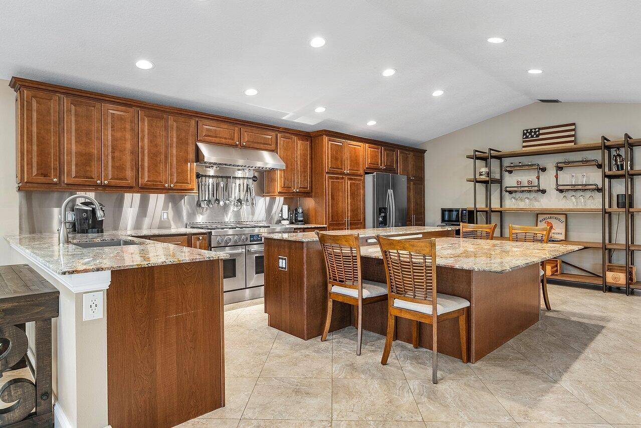 9077 NW 49th Place is nestled in Coral Springs, Florida ; this Pine Ridge home presents a blend of luxury and practicality.