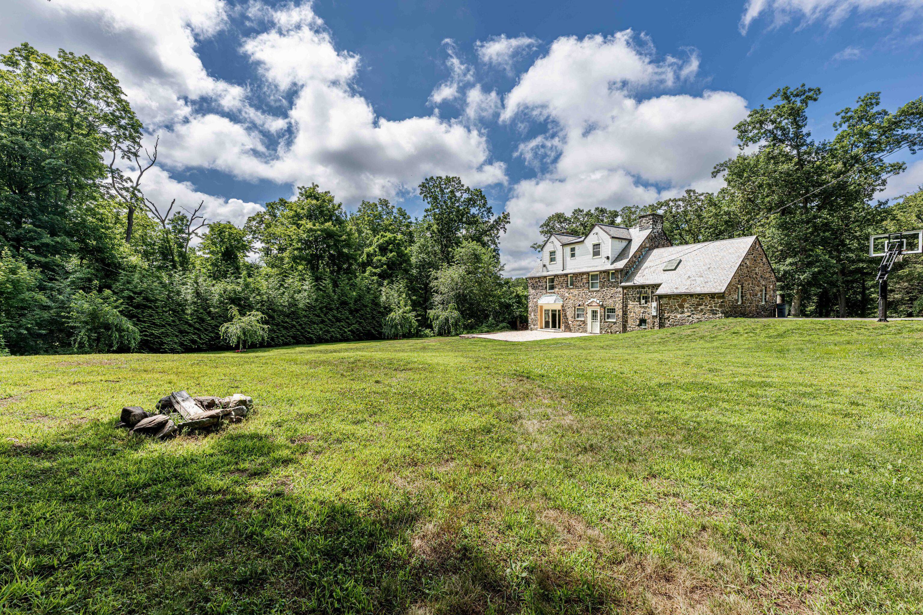 Nestled in a serene and sought after Bethany Woods neighborhood, this stately stone home exudes both timeless charm and casual elegance.