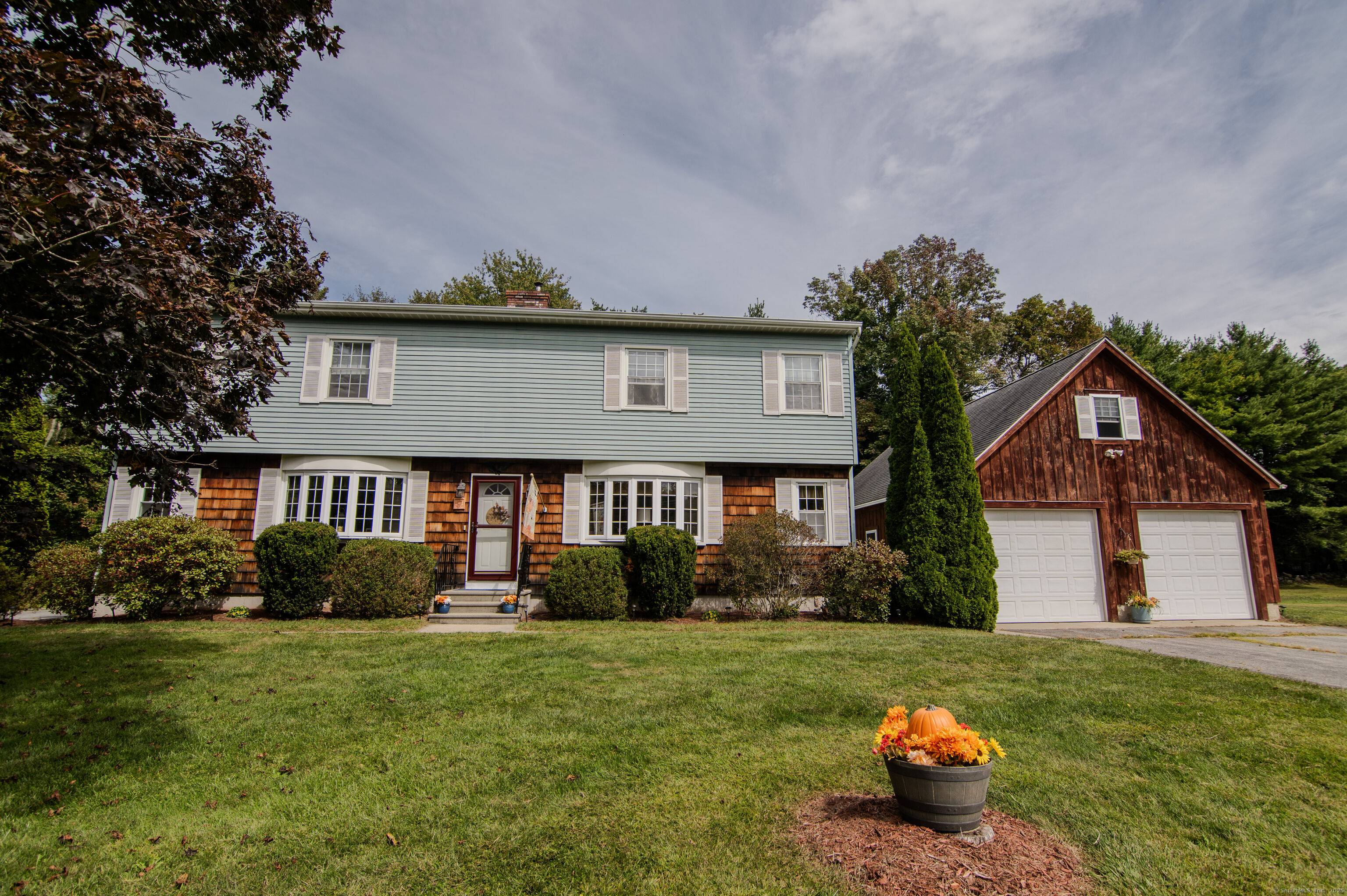 Beautifully maintained Colonial home sits far off road on a pristine lot.