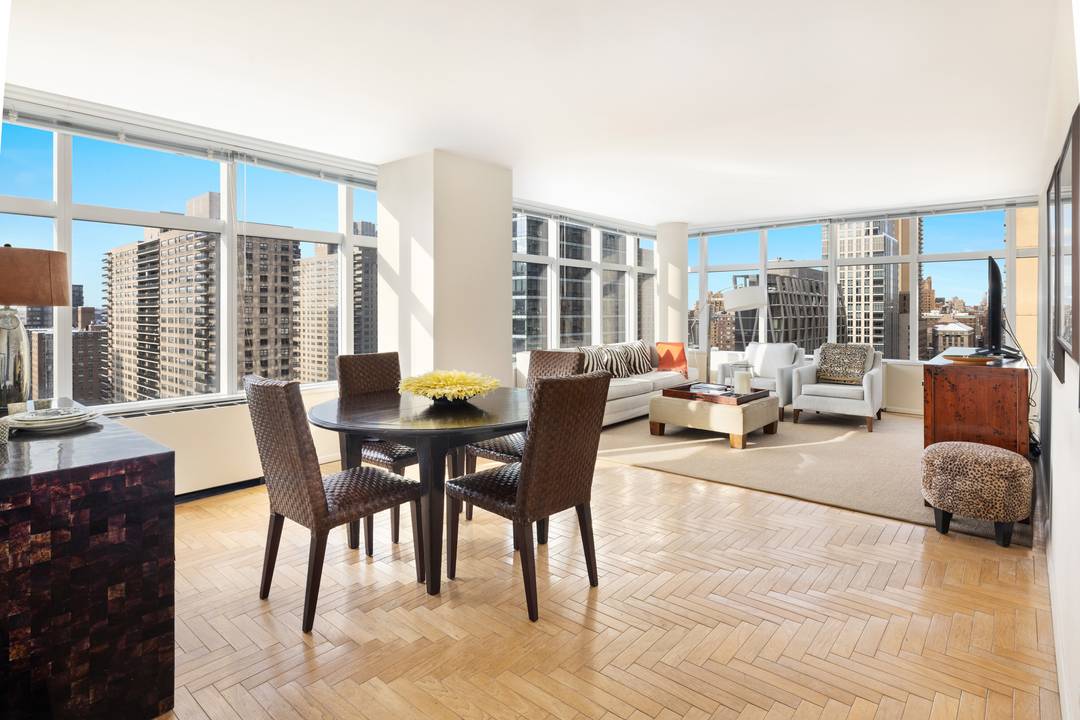 High above Lincoln Square, Residence 19B at 3 Lincoln Center enjoys sweeping views of the Hudson River and the Manhattan skyline through dramatic floor to ceiling windows.