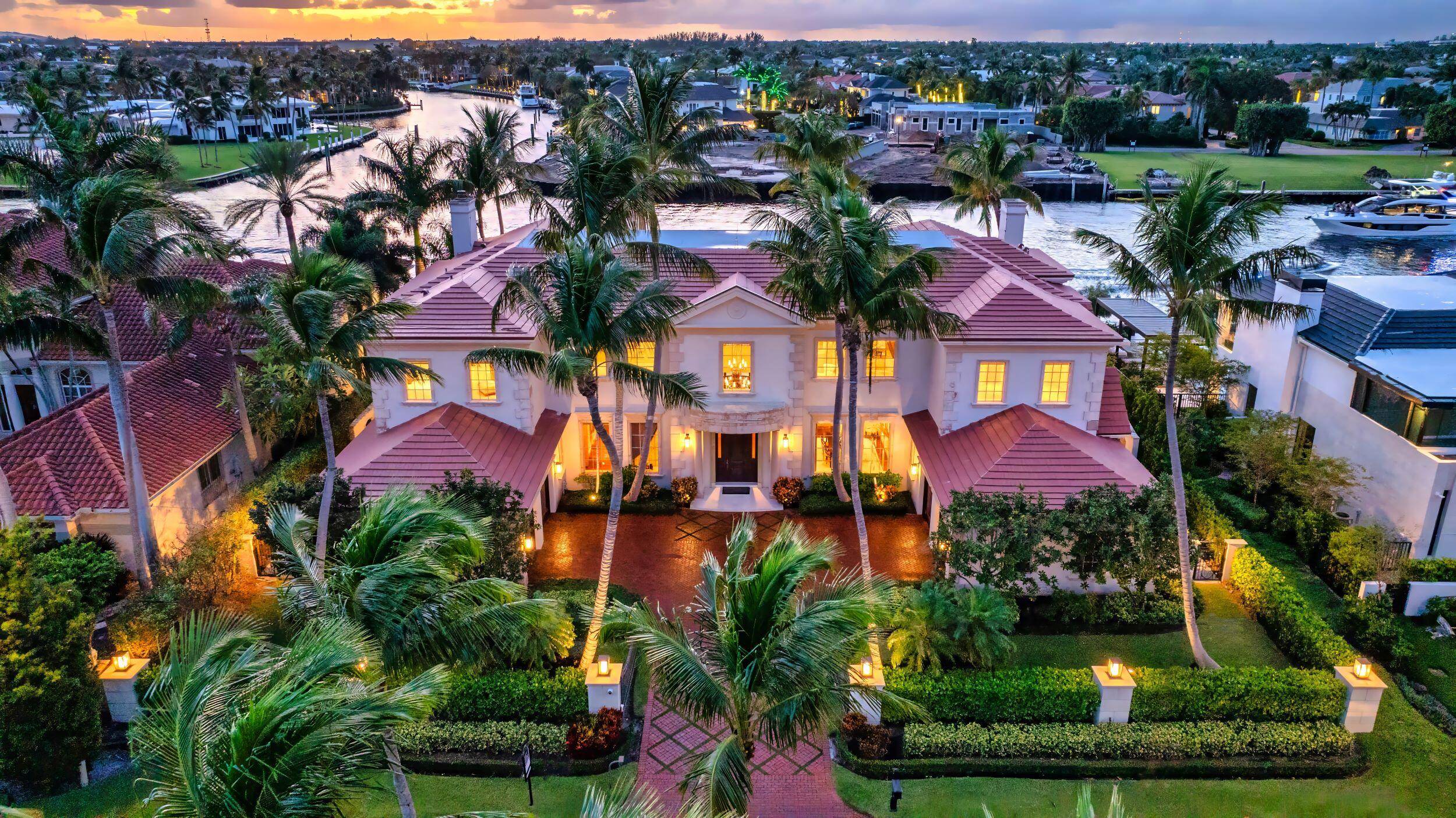 Gated Palm Beach inspired Tropical Georgian sited on 123 feet of Intracoastal with wide views overlooking Royal Palm's Grand Canal and originally built by acclaimed Frankel Estate Homes, Carlos Martin ...