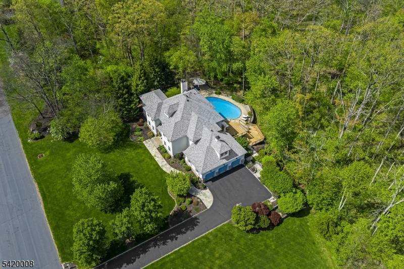 Set on over seven acres of sweeping lawns and private wooded surroundings, this exceptional five bedroom, four full and one half bath residence offers a refined, design forward aesthetic with ...