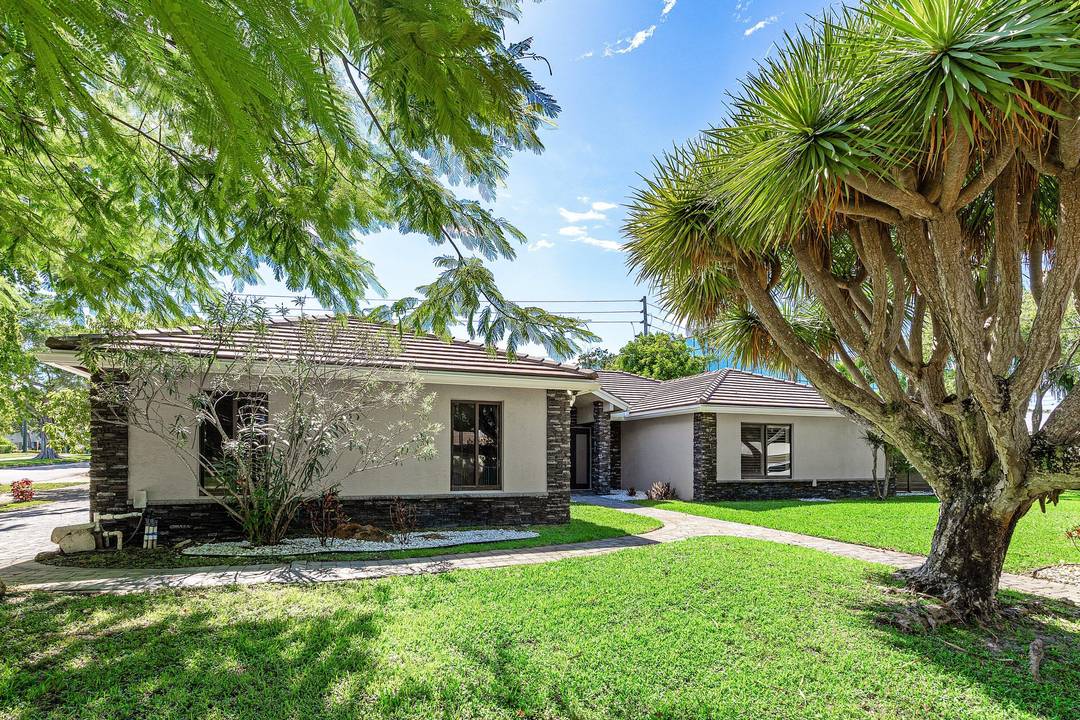 The exterior was redesigned with a refreshed fac ade, remodeled pool, new pavers, updated fencing, and a custom faux finish garage door.