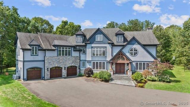 This stunning custom estate in Easton sits on over four private acres with a long tree lined driveway.