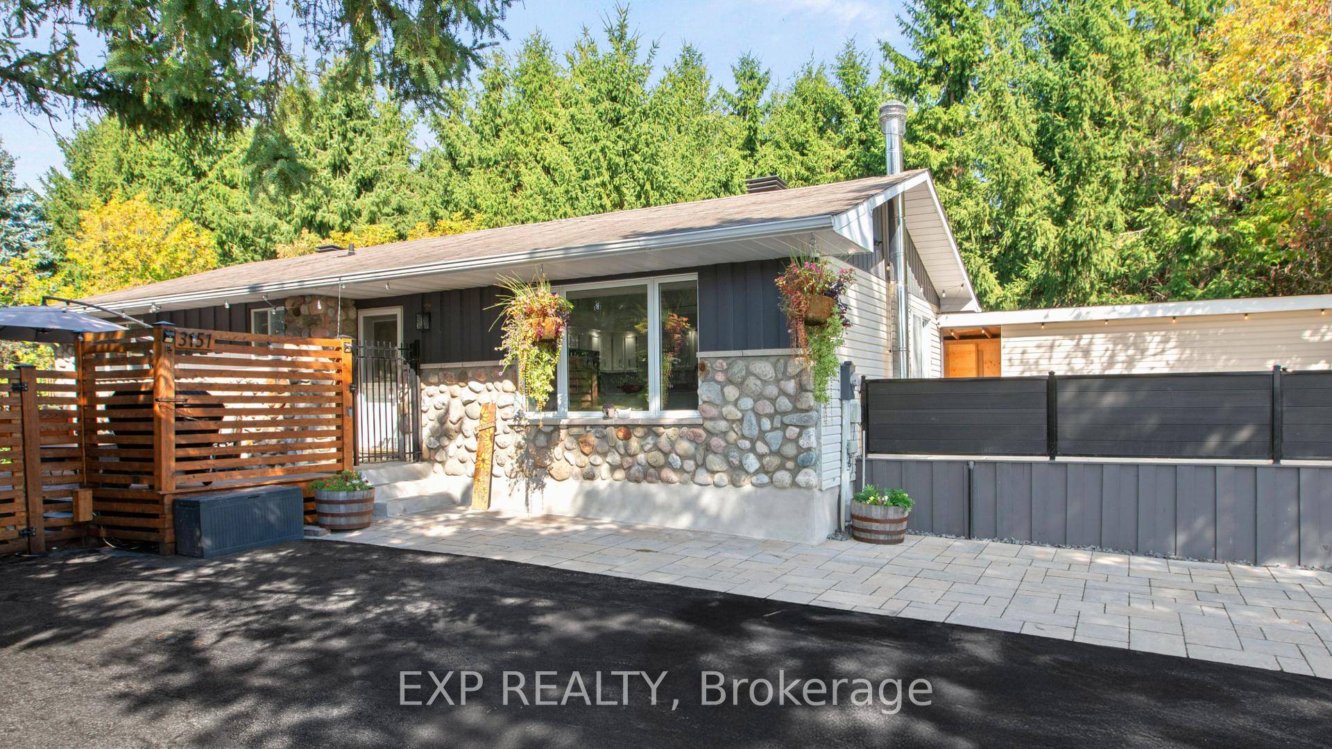 Welcome to this beautifully updated stone and wood bungalow, nestled on a spacious and private lot surrounded by evergreens and backing onto a tranquil forest.