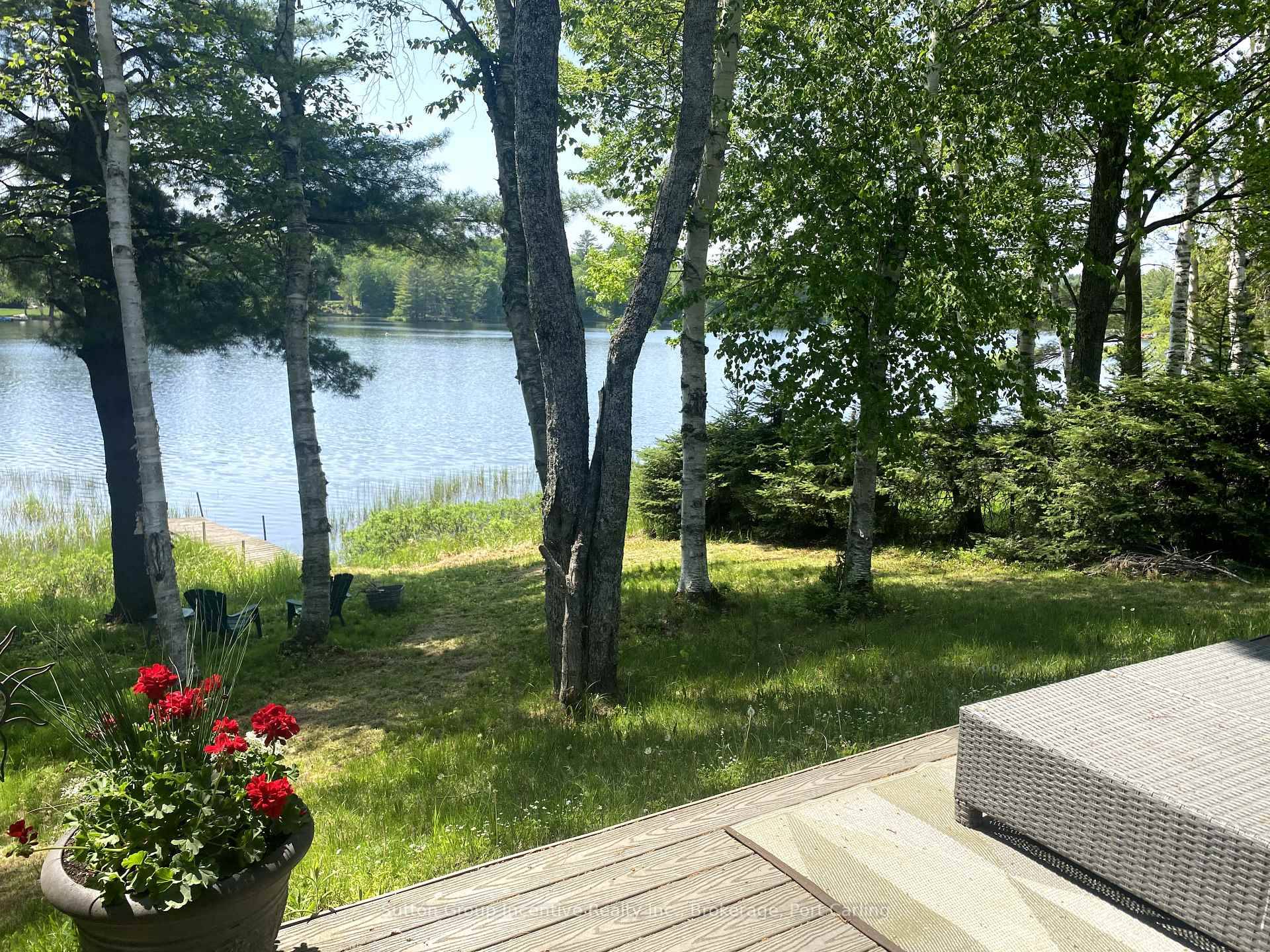 This beautiful family home or cottage is just under an acre of level property with a gentle slope to the natural sandy shore and dock.