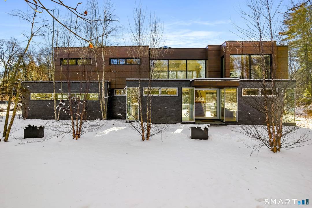 Set on over two private acres with its own pond and just one mile from town, this architecturally significant modern residence is a rare convergence of design, technology, and setting.