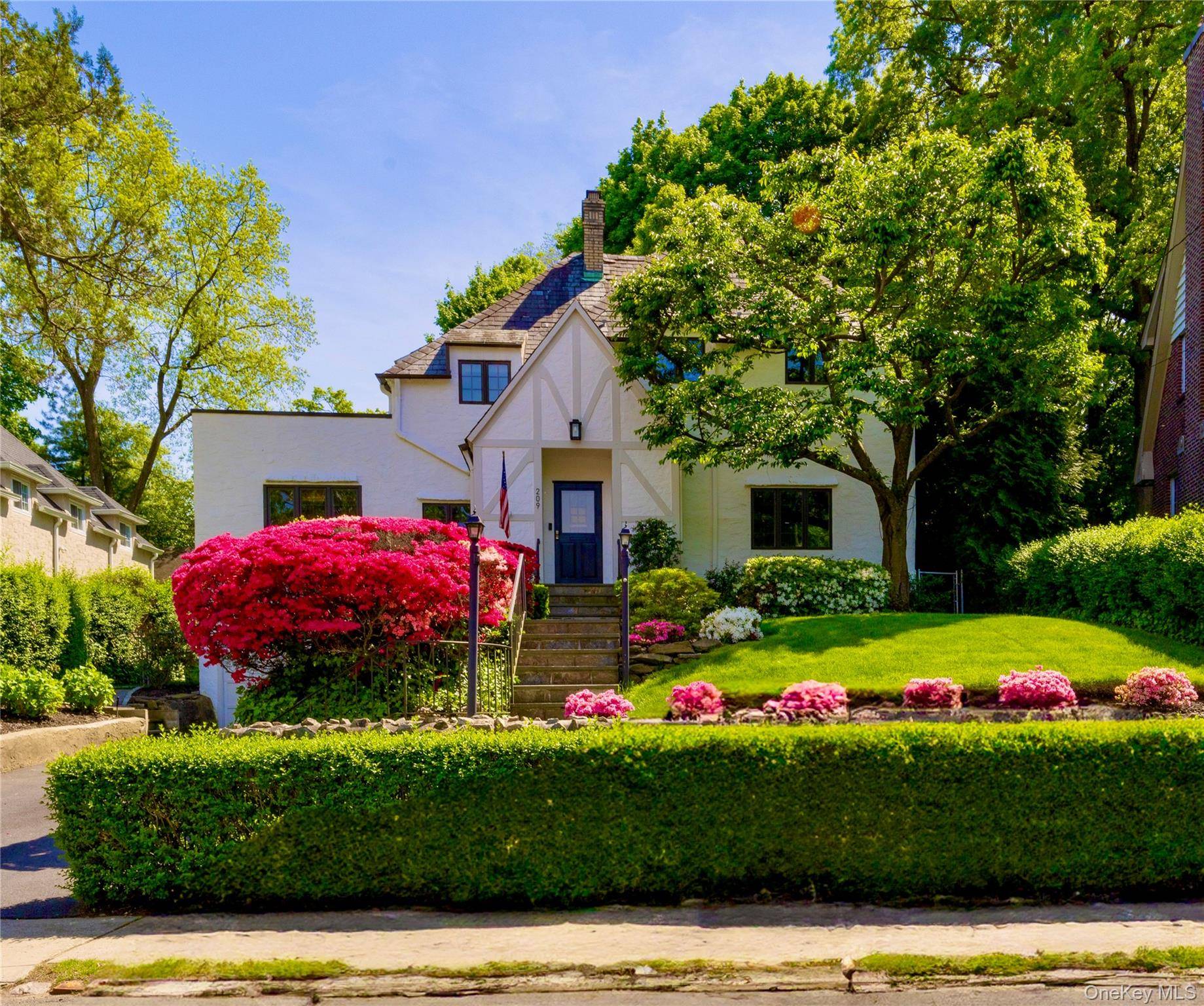 Classic stucco English Tudor nestled in the heart of iconic Cedar Knolls Bronxville, NY.