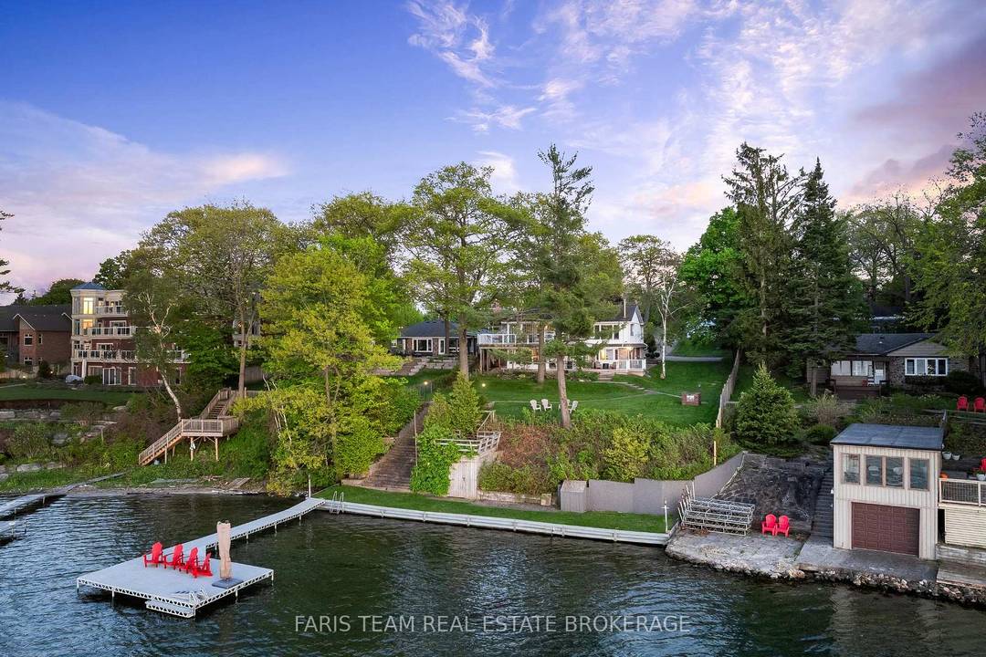 Top 5 Reasons You Will Love This Home 1 Welcome to an exceptional waterfront retreat, boasting over 91' of pristine sandy shoreline and a steel retaining wall, where sunsets paint ...