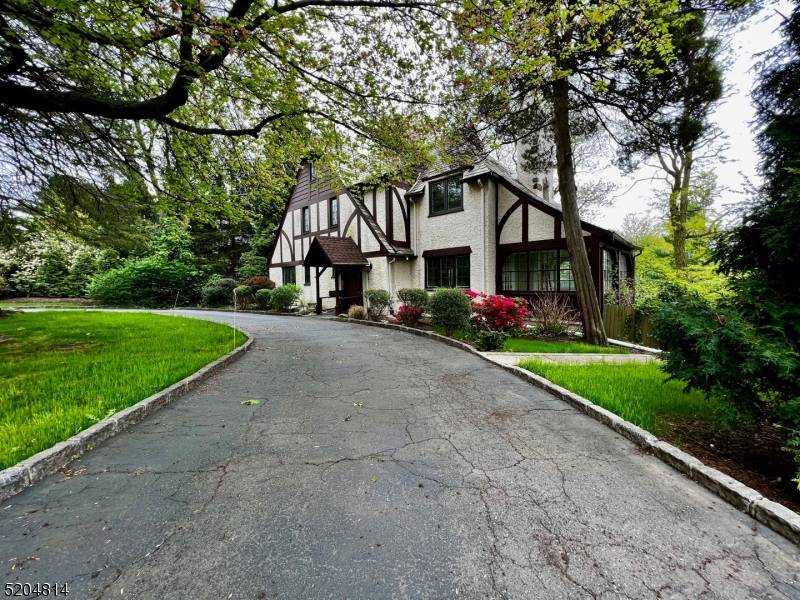 Lovely Short Hills Tudor, tasteful landscape with a circular drive heated 2 car garage with remote access.