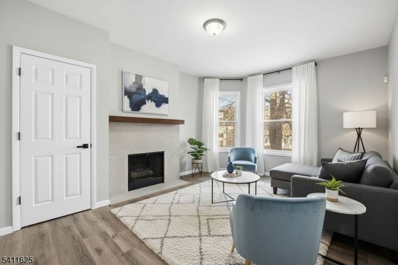 Charming and spacious 3 family home features a welcoming front entry with steps leading to a bright enclosed porch, perfect for a sunroom, home office, or relaxing sitting area.