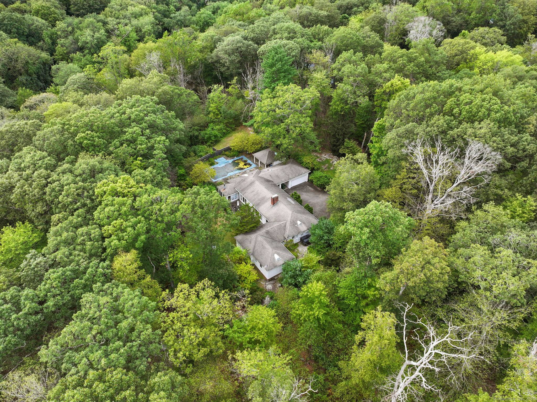 Mid century modern ranch with in ground pool, pool house and two additional out buildings.