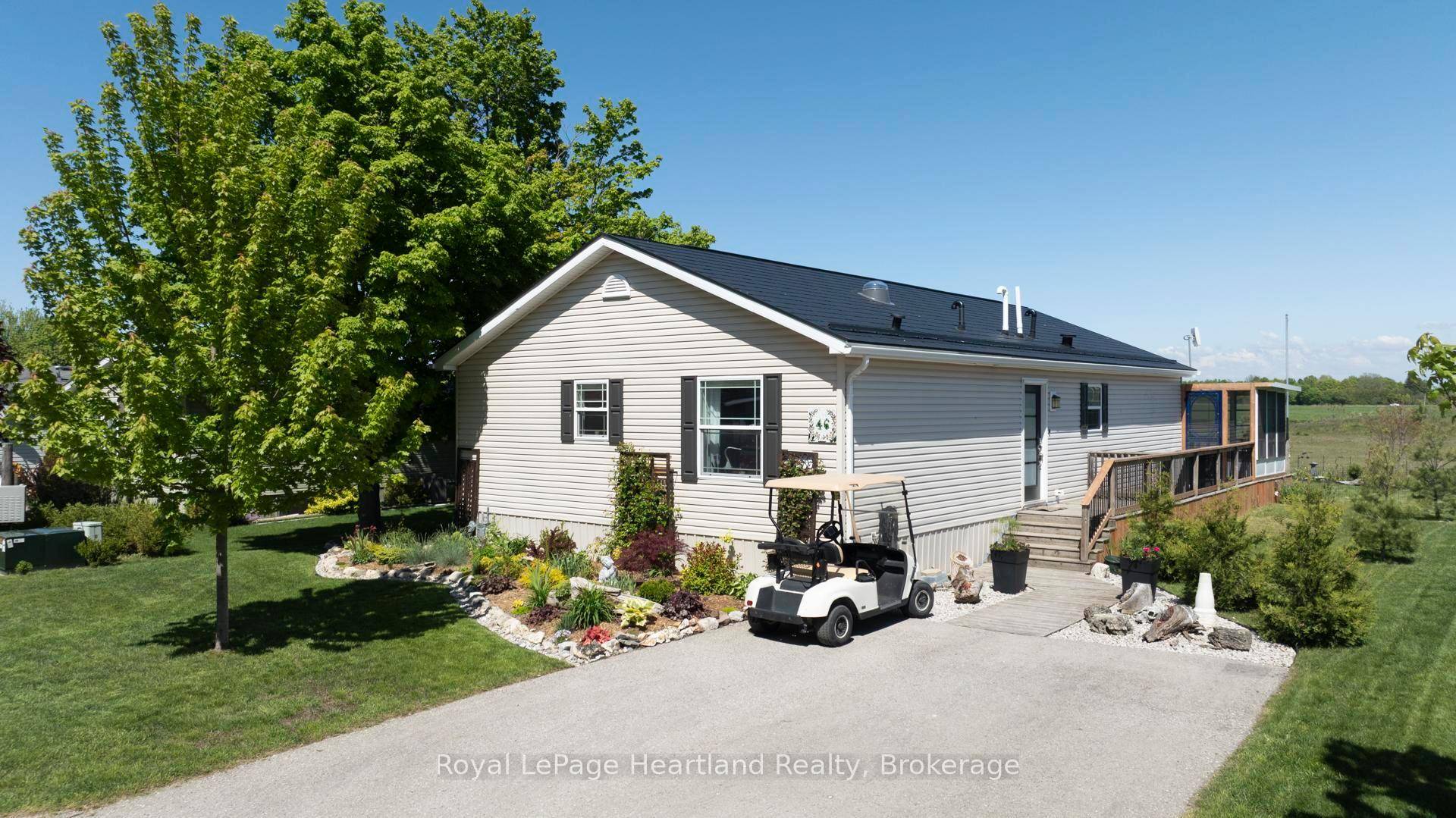A gardeners paradise ! ! Stunning perennial gardens line the front of this 2009 Hart Home, now being offered for sale in the lakefront adult community, Meneset on the Lake.