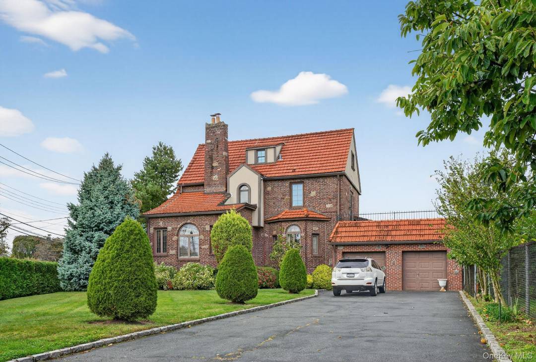 Large Landscaped Brick Tudor with 4 5 bedrooms, 3 full bath and 1 half bath with very large 2 car garage private parking for 10 cars.