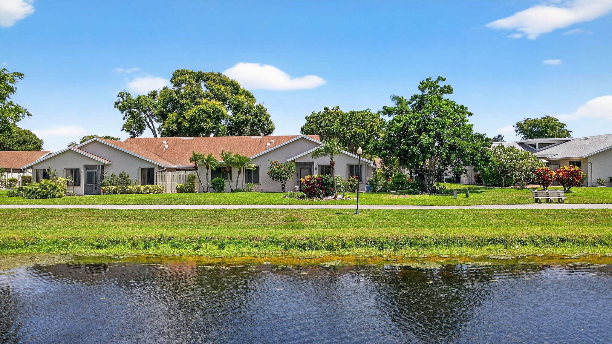 Beautifully situated on a tranquil LAKE, this spacious one story, CORNER villa offers 2 bedrooms, 2 bathrooms, and a flexible den home office.