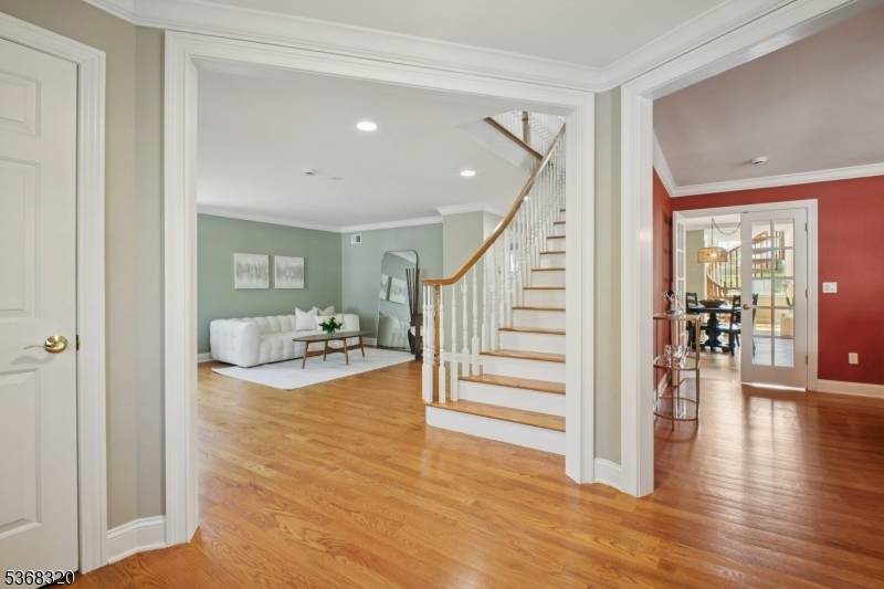 Charming custom home with a distinctive fa ade, featuring stone and Hardie Plank siding, and a beautifully landscaped front yard.