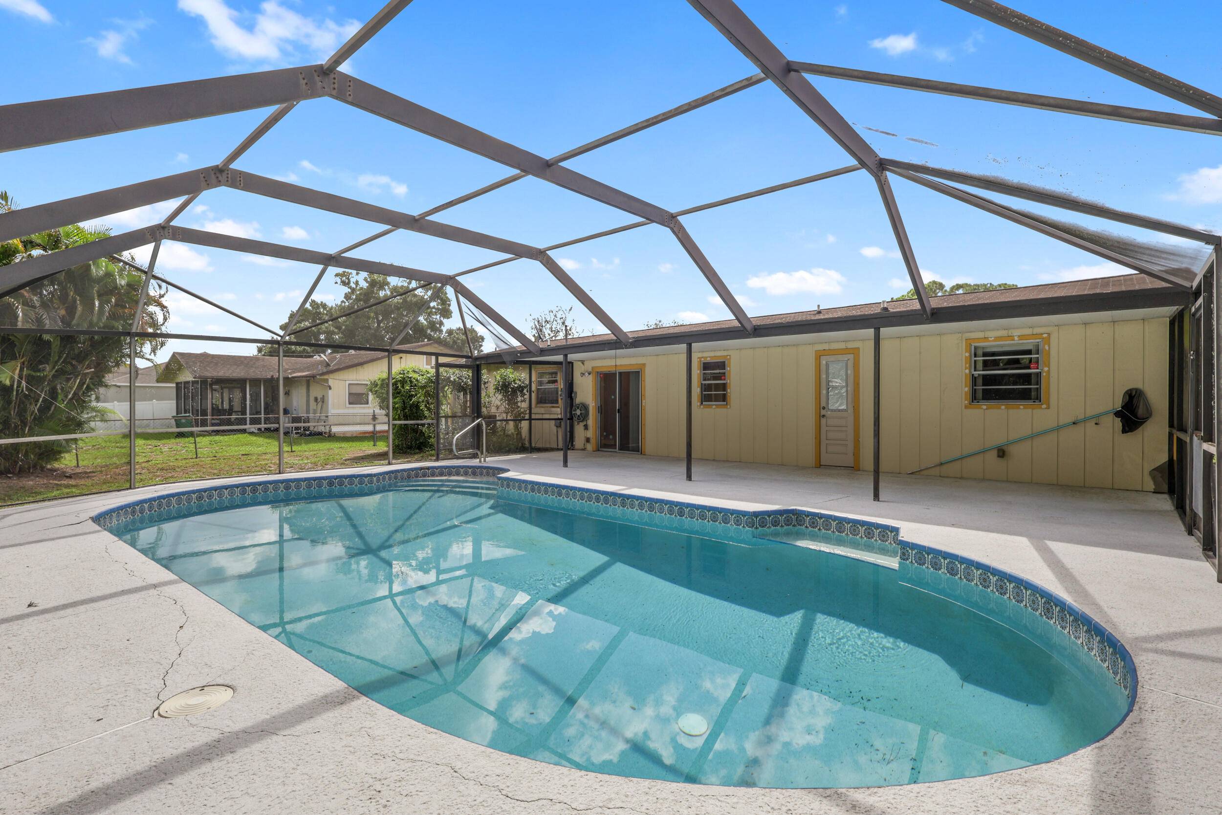 This house features a screened in pool with a cabana bath and a shed out back.