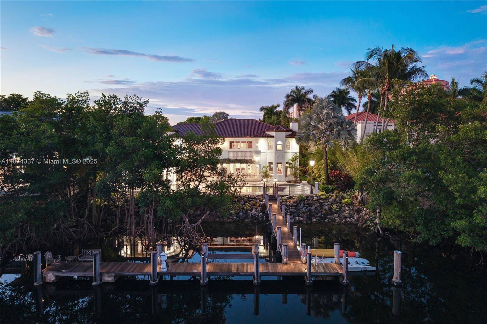Inside guard gated Islands of Cocoplum, this private estate sits far back from the street on one of the community s largest no bridges to bay waterfront lots.