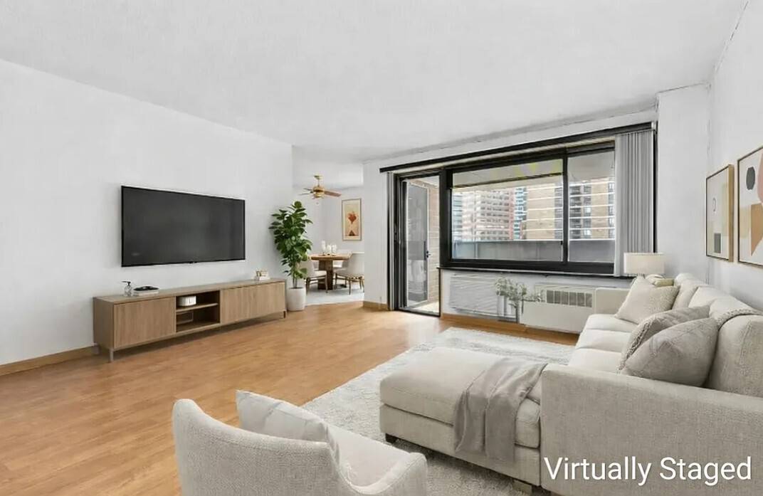 Large alcove studio with a southeast exposure, private balcony, and open city views extending toward the East River.