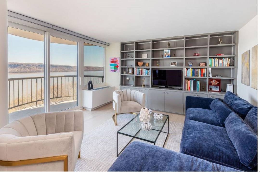 NOTHING SHORT OF PHENOMENAL A wall of windows spanning the living and dining room magnificently frames the unobstructed views of the Hudson River, the Palisades and beyond.