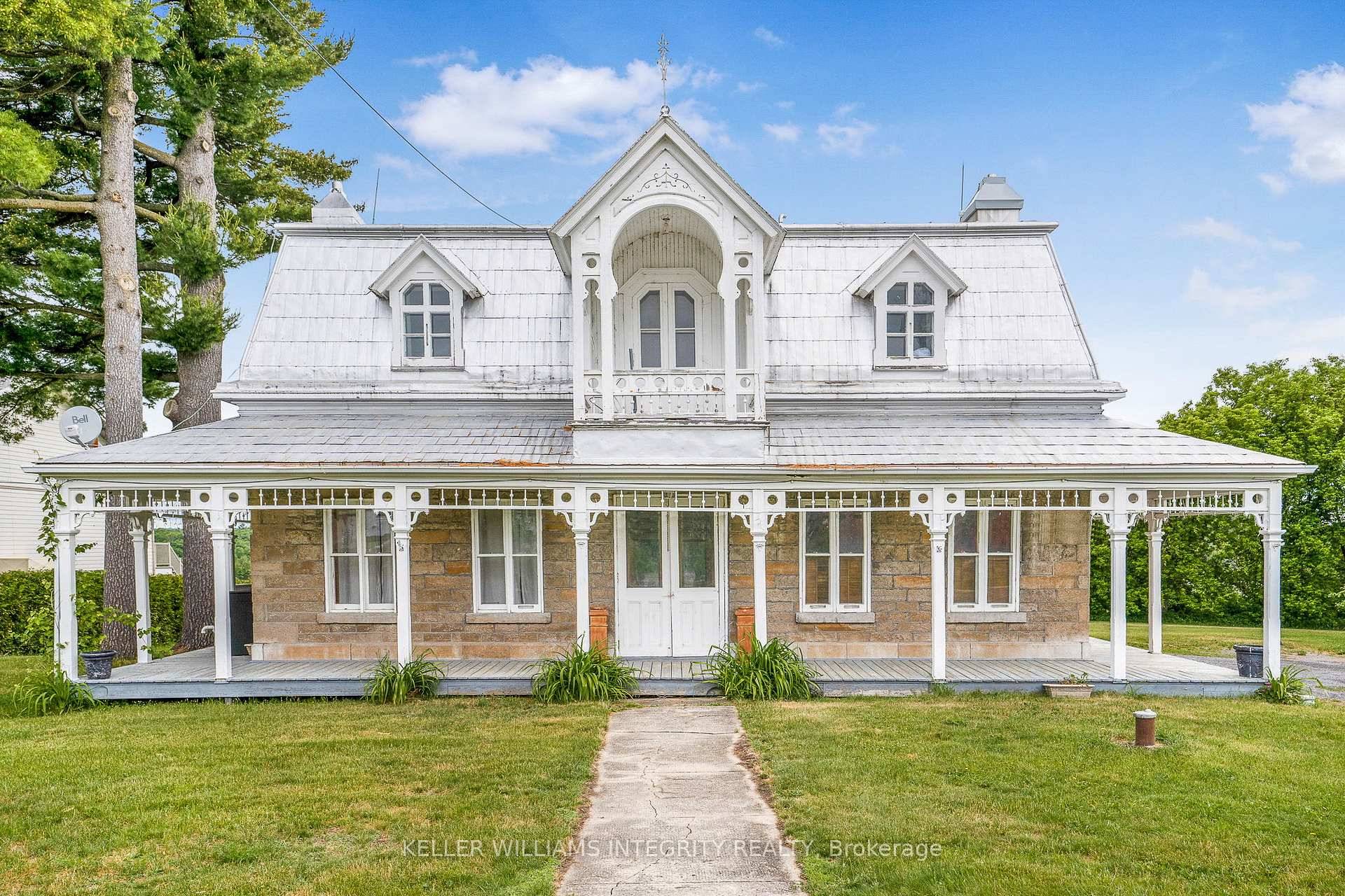 Charming historic stone house with wraparound ornamented veranda boasting over 3000 sq ft above grade and 5 bedrooms on 1.