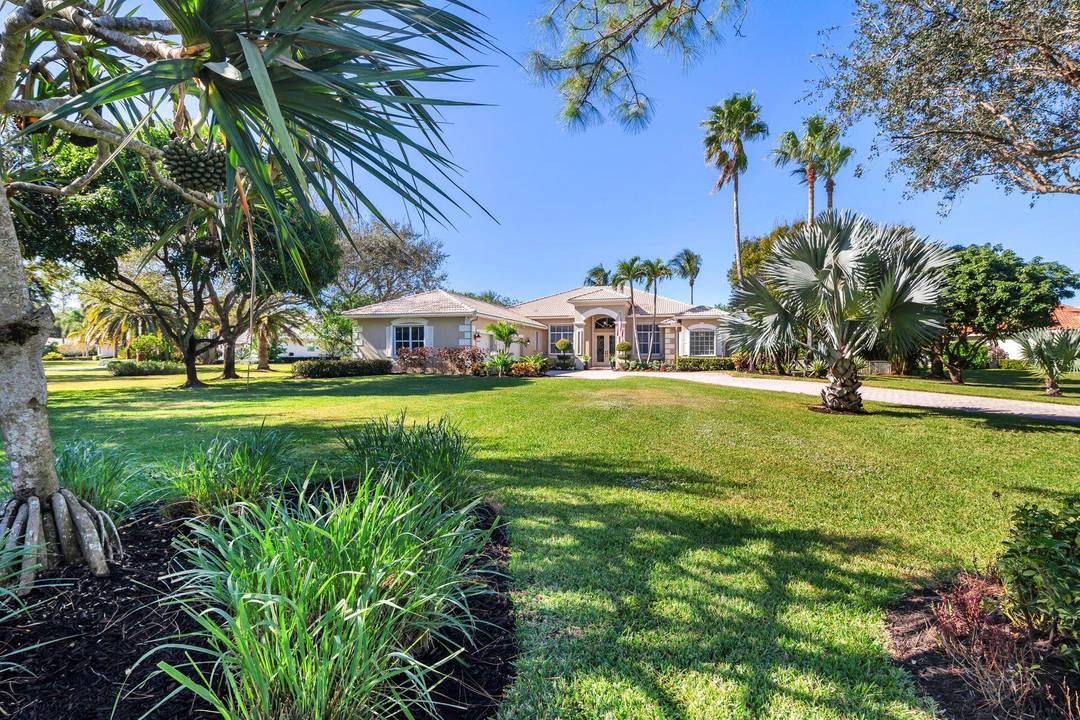 Custom single family house on a private lushly landscaped acre parcel in the gated community of Bay Hill Estates.