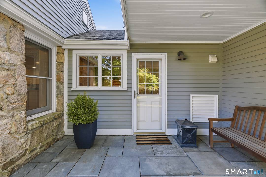 Tucked behind mature trees and framed by classic stone walls, this remarkable Stonington property feels more like a private country estate than a traditional residence.