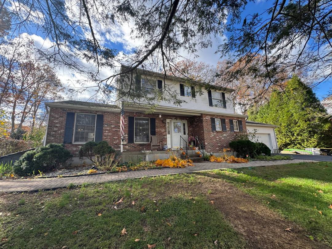 Beautiful backyard featuring stone walkways, a brick patio, serene sitting areas, lush mature plantings, and a tranquil waterfall.