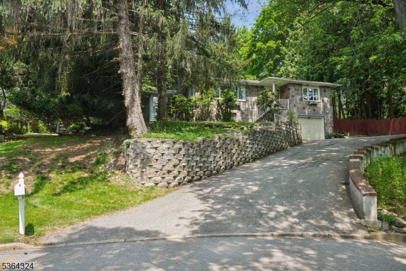 Tucked away on over 2 acres of beautiful, private wooded lot, this charming stone Ranch offers a serene lifestyle surrounded by nature.