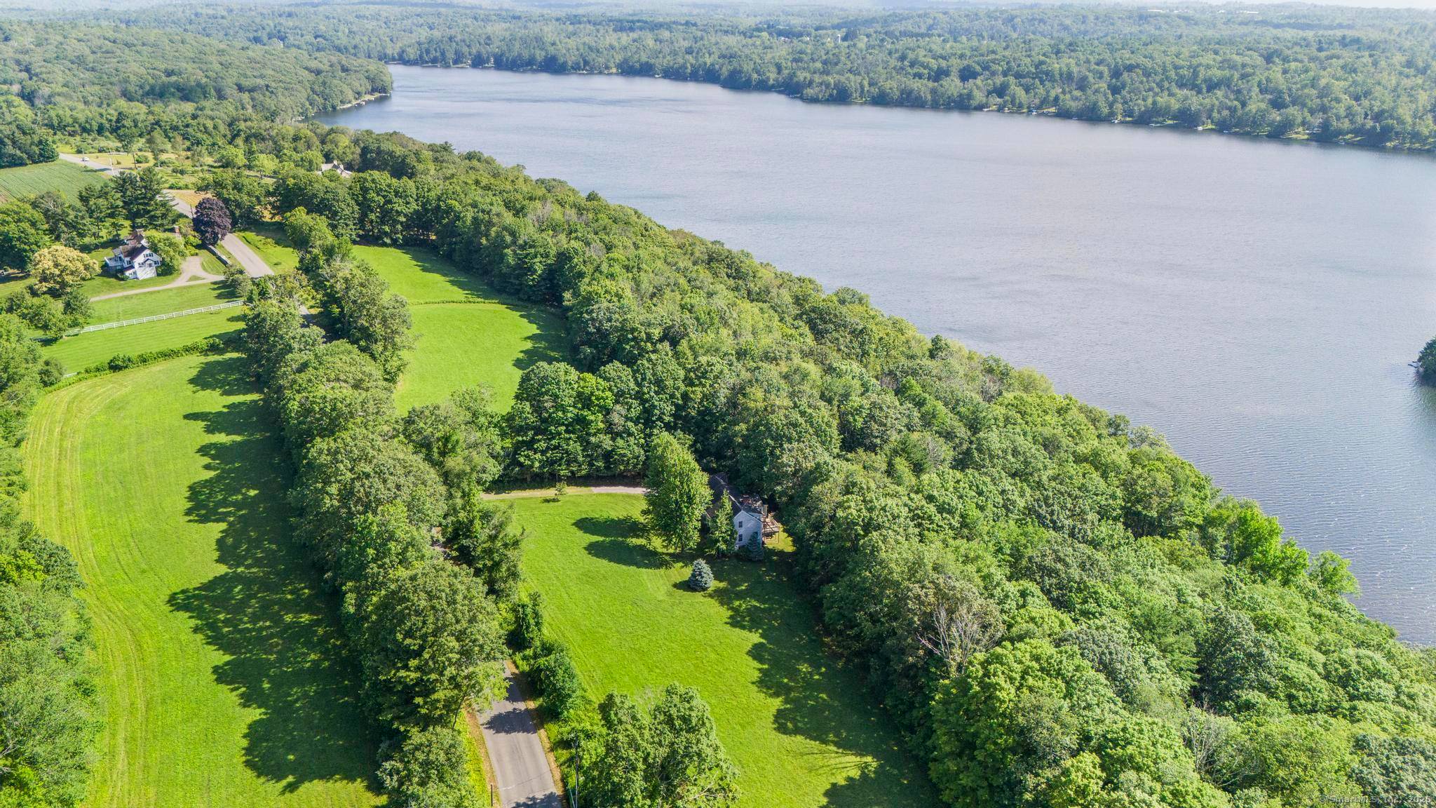 Nestled along the coveted west shore of Woodridge Lake, 455 Milton Road reveals a rare sanctuary of lakefront elegance.
