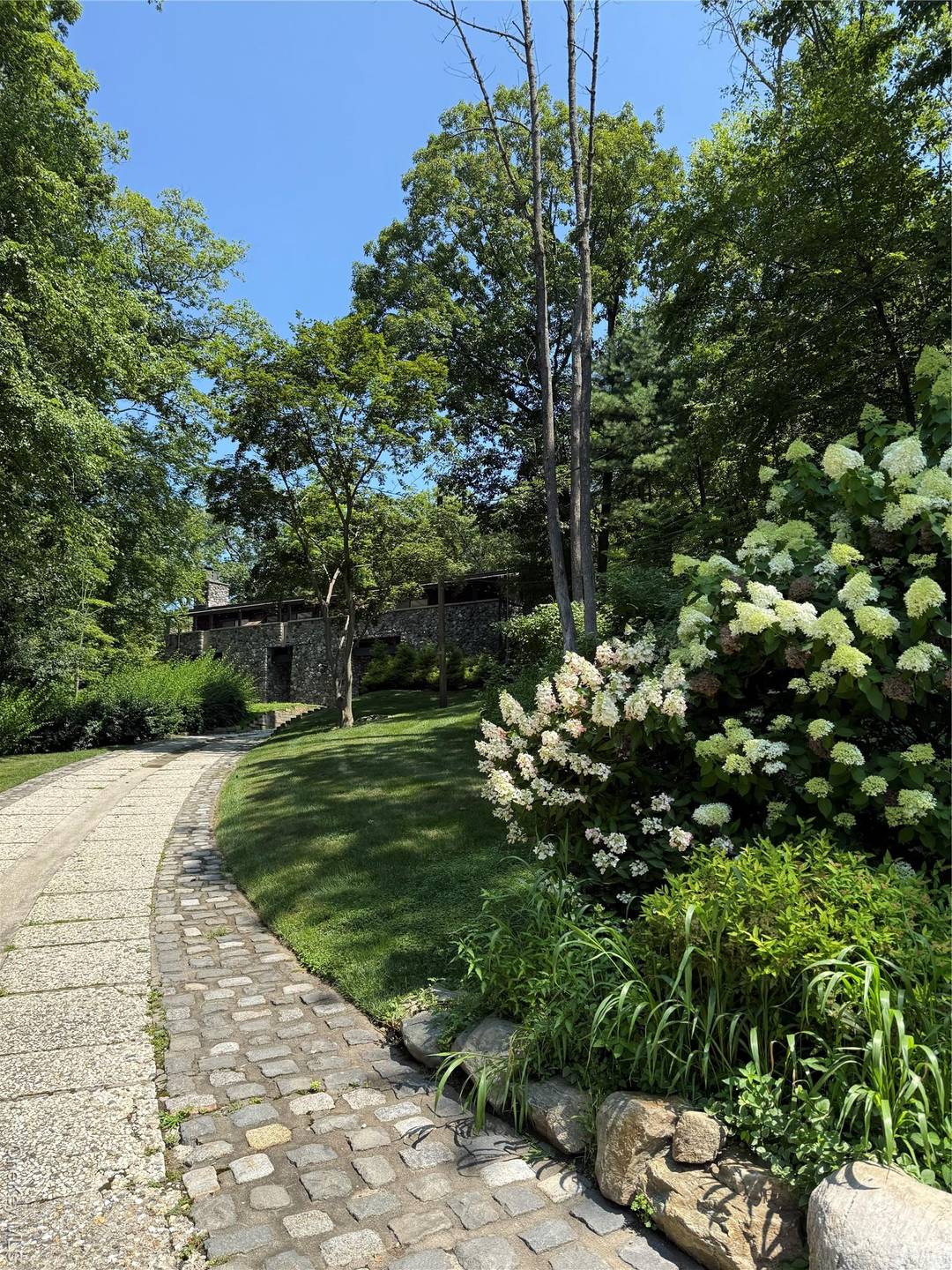 MIDCENTURY MODERN A SEAMLESS CONNECTION WITH NATURE Nestled atop a striking boulder with panoramic views of Sterling Forest State Park, this spectacular home is a true masterpiece.