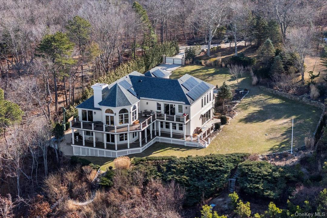 Set high above the shoreline with sweeping western views across Long Island Sound to the Connecticut coast, this exceptional East End estate offers rare privacy, scale, and direct beach access ...