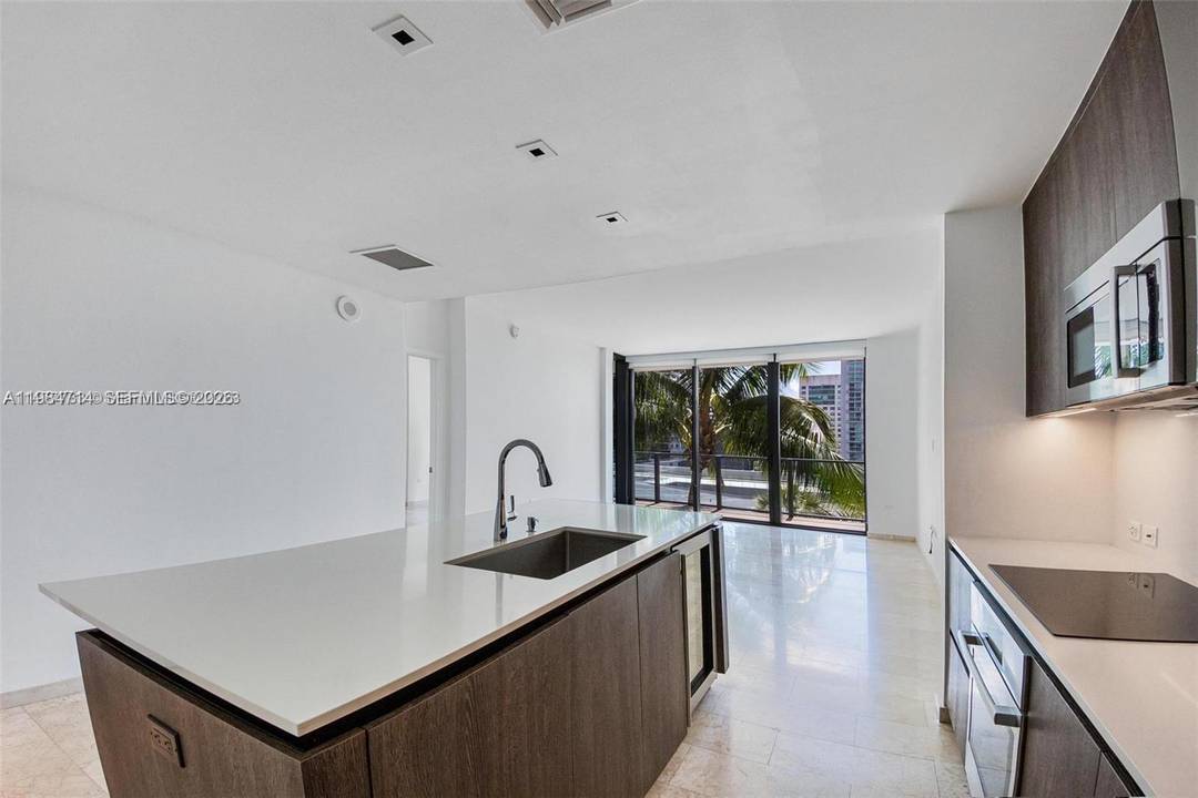 This beautifully appointed residence boasts an open concept layout with sweeping views of the garden, city skyline, and Miami River.