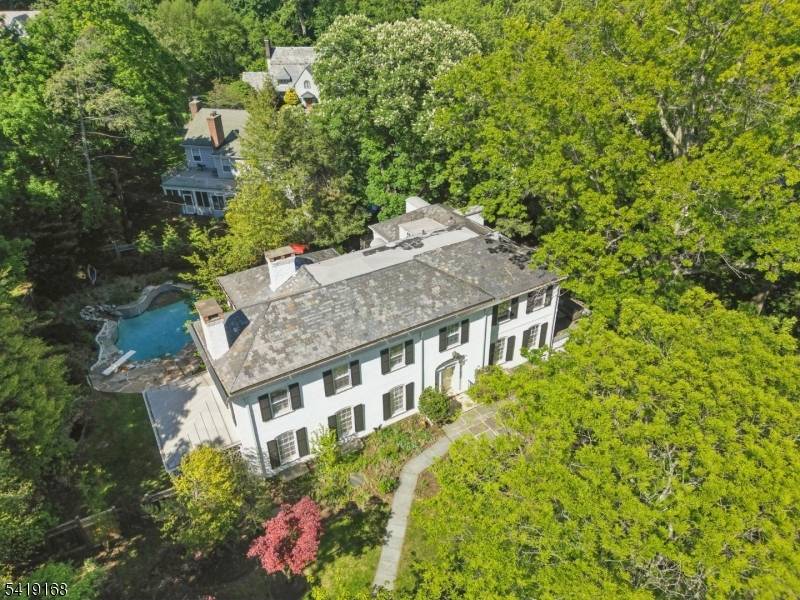 Magnificent over 5000 SQ FT Georgian revival Colonial with captivating outdoor pool surrounded by gold quartzite flagstone patio and lush plantings.