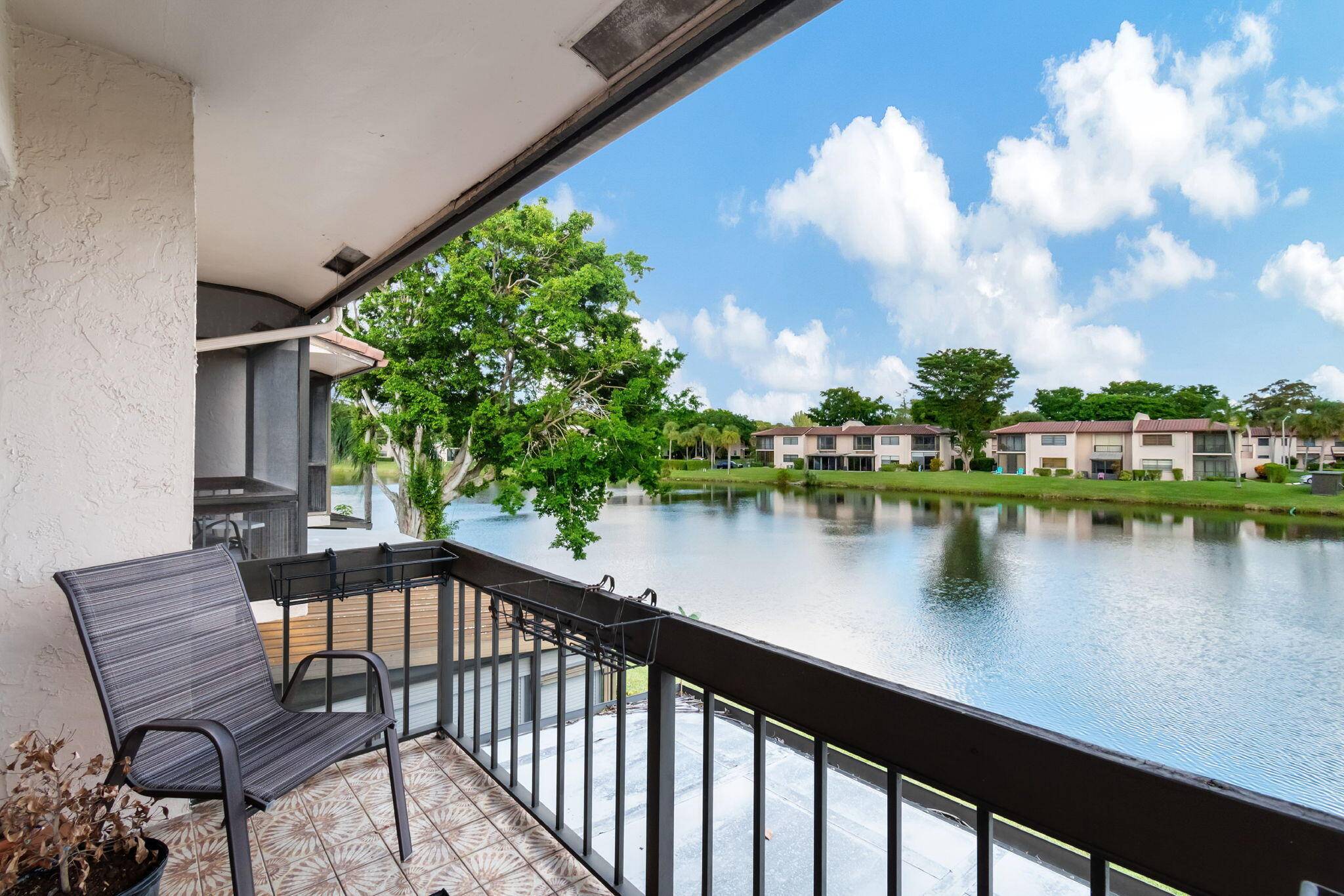 Enjoy the peaceful panoramic water view from this lovely townhouse in the beautiful Vistas of Boca Lago.