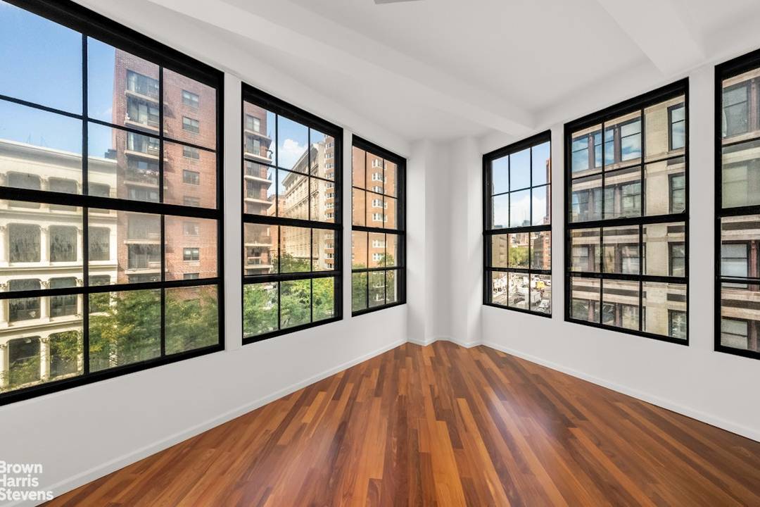 This bright corner 2 bedroom 1 bathroom loft offers soaring 13 foot concrete ceilings, wood floors, nine 10' cast iron casement windows facing North, East, and West.