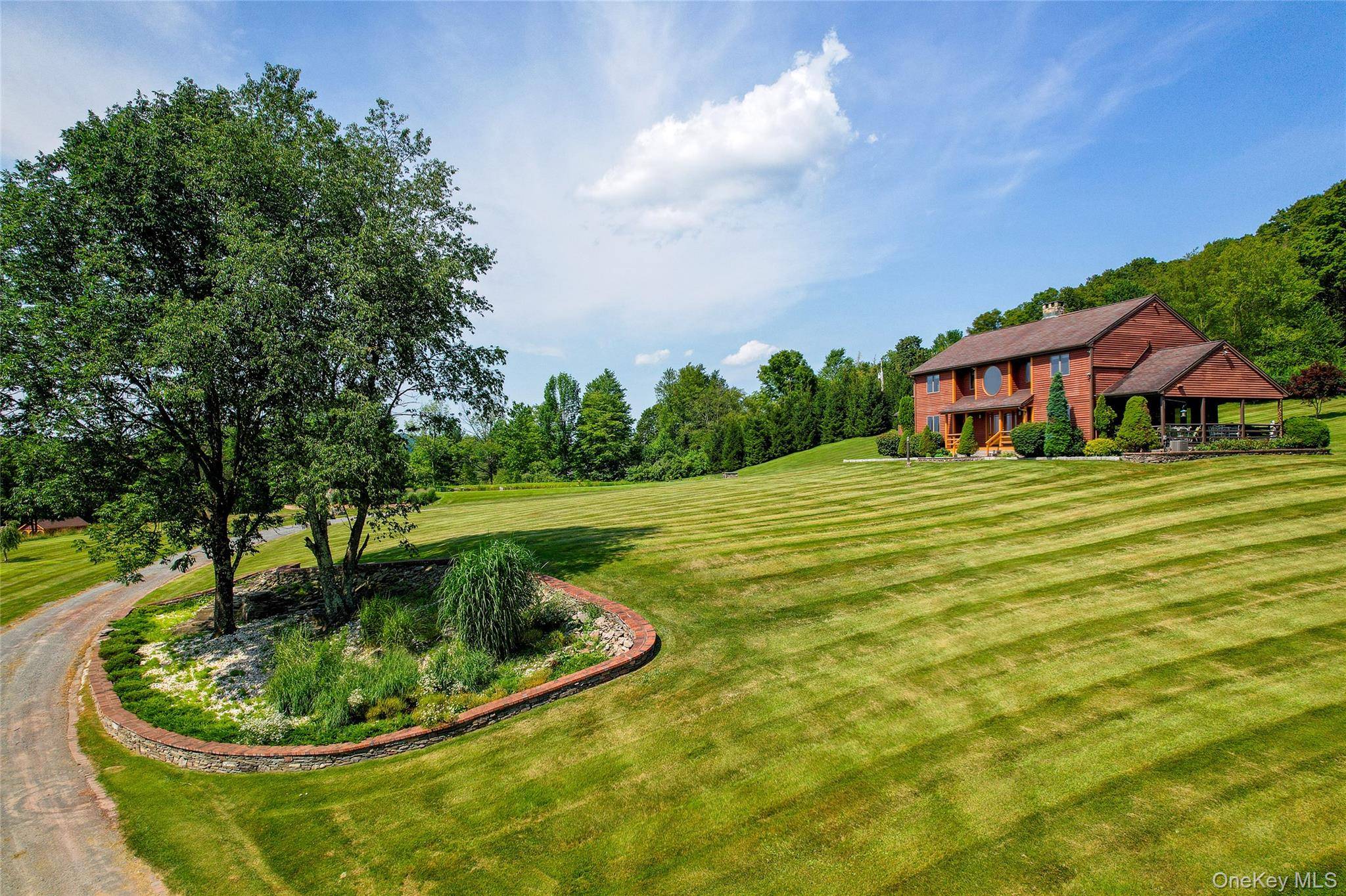 This mountaintop contemporary sits on 15 private acres with unparalleled views of the western Catskills, miles of hills and valleys, and an expansive, rolling lawn.