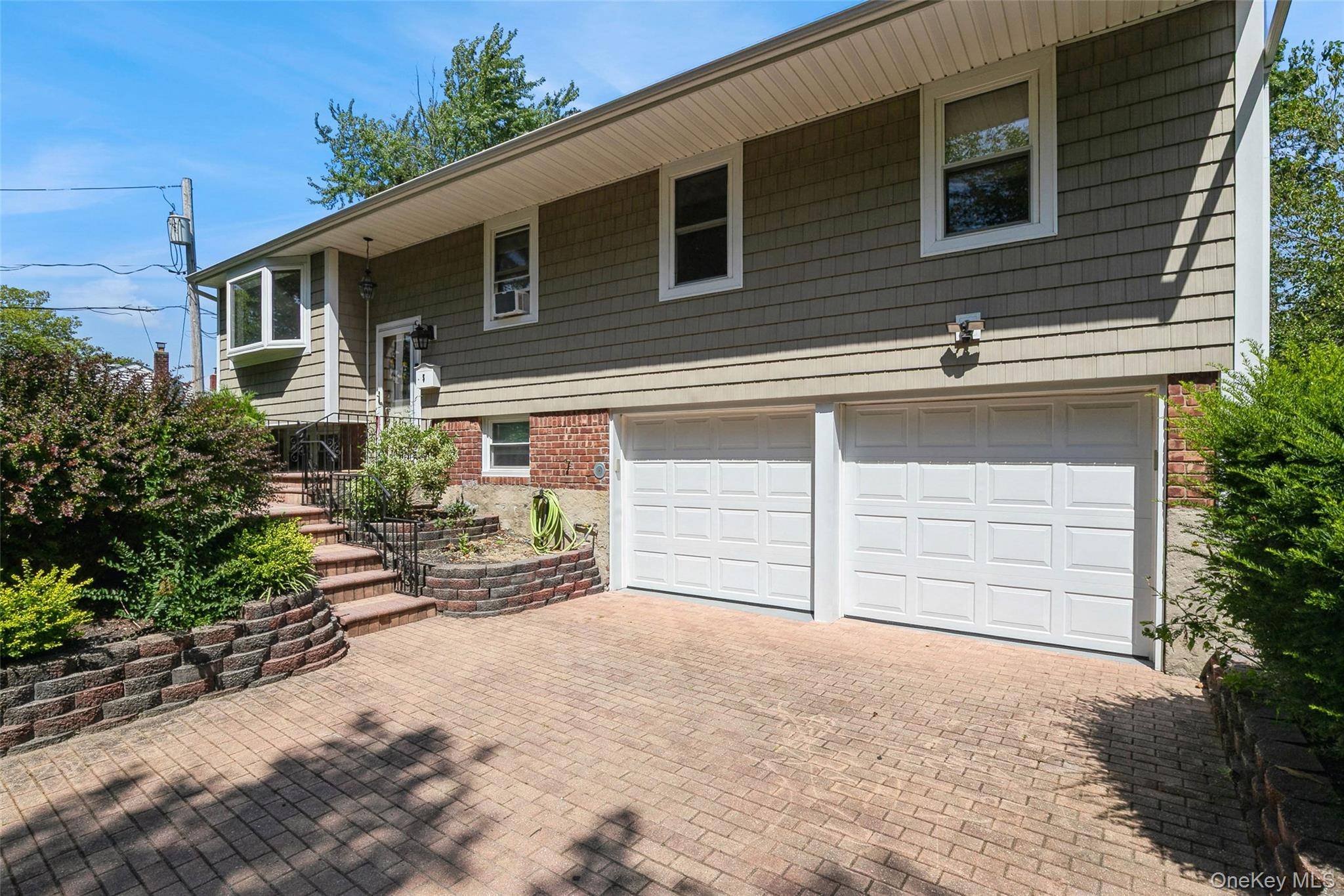 BEAUTIFULLY RENOVATED HOME featuring a new roof, new siding, and a freshly paved driveway.
